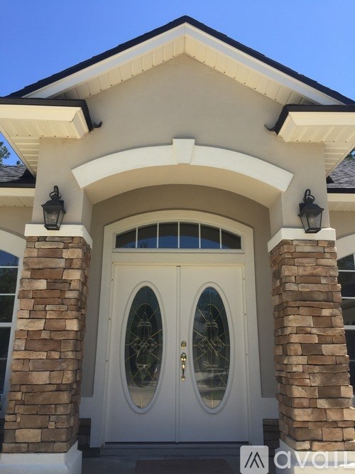 A white house with a glass window and a door.
