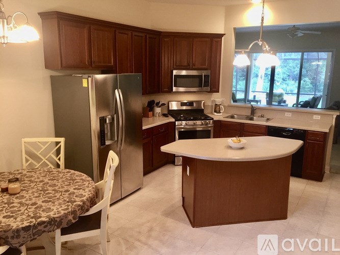 A kitchen with a refrigerator, microwave, oven, and sink.