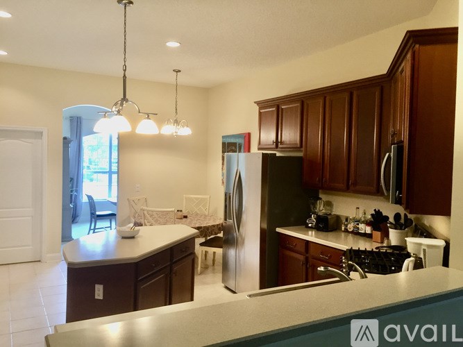 A kitchen with brown cabinets and a stainless steel refrigerator.