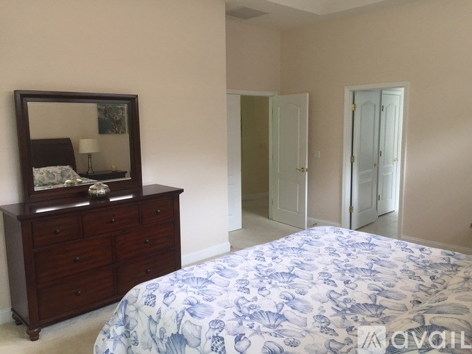 A bedroom with a bed, dresser, and mirror.