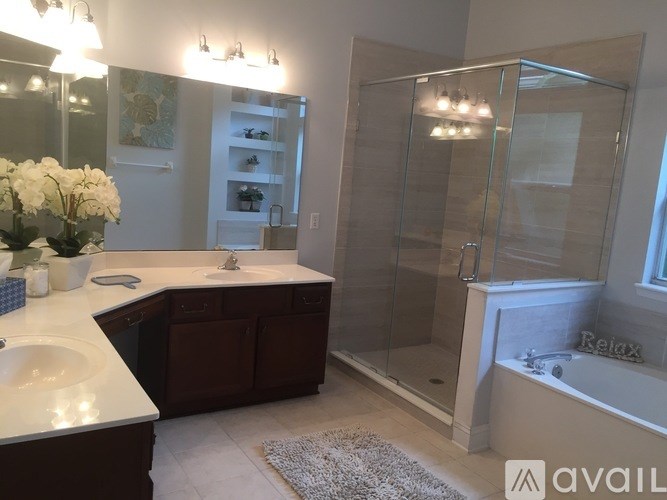 A bathroom with a glass shower stall and a white bathtub.