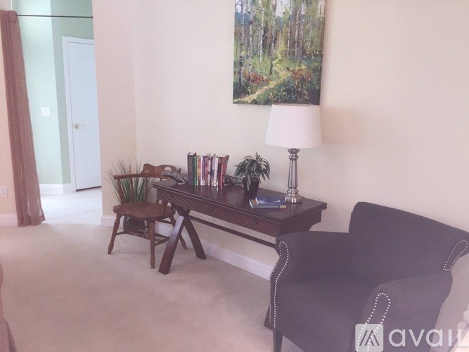 A living room with a couch, chair, and a lamp.