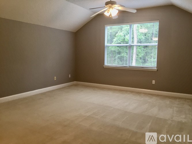 A room with a ceiling fan and a window with blinds.