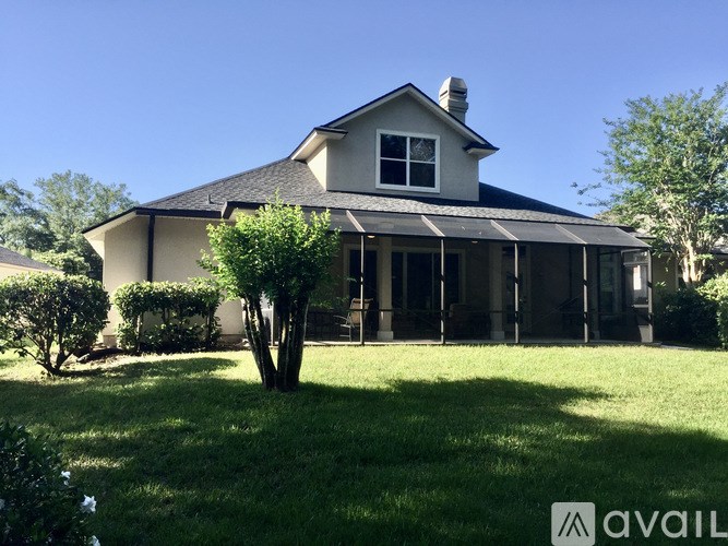 A house with a large front yard and a tree in the front.