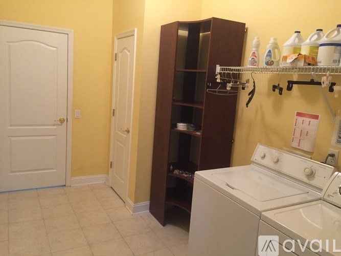 A laundry room with a washer and dryer and a brown cabinet.