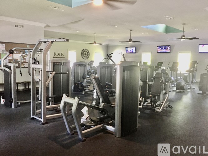 A gym with a variety of equipment including treadmills, weights, and exercise machines.
