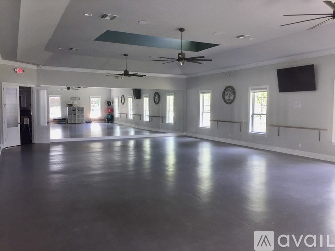 A spacious room with a dark floor and white walls.