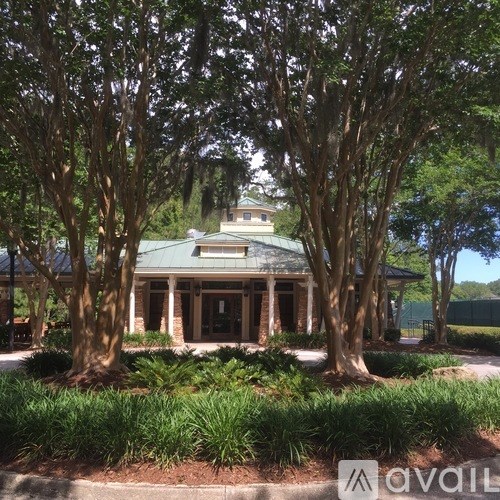 A house with a green roof is surrounded by trees.