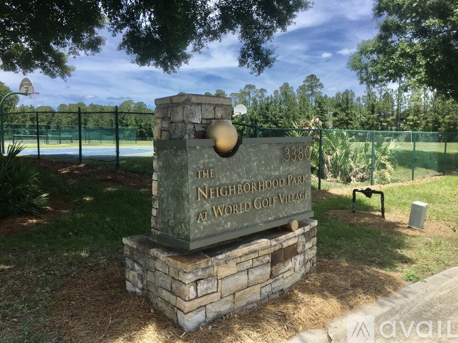A sign for The Neighborhood Park at World Golf Village stands in a grassy area.
