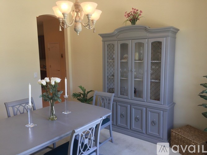 A dining room with a grey table and chairs.
