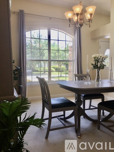 A dining room with a table and chairs.