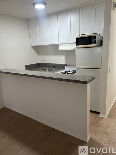 A kitchen with white cabinets and a granite countertop.