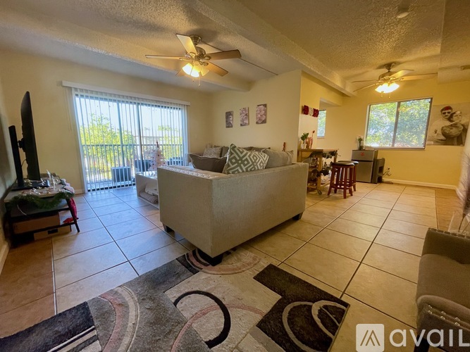 A living room with a couch, a television, and a rug.
