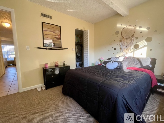A bedroom with a black bed and a chandelier.