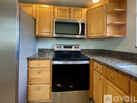 A kitchen with wooden cabinets and granite countertops.