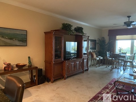 A living room with a wooden entertainment center and a painting on the wall.