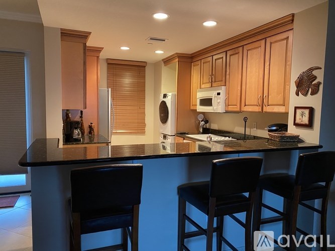 A kitchen with wooden cabinets and black countertops.