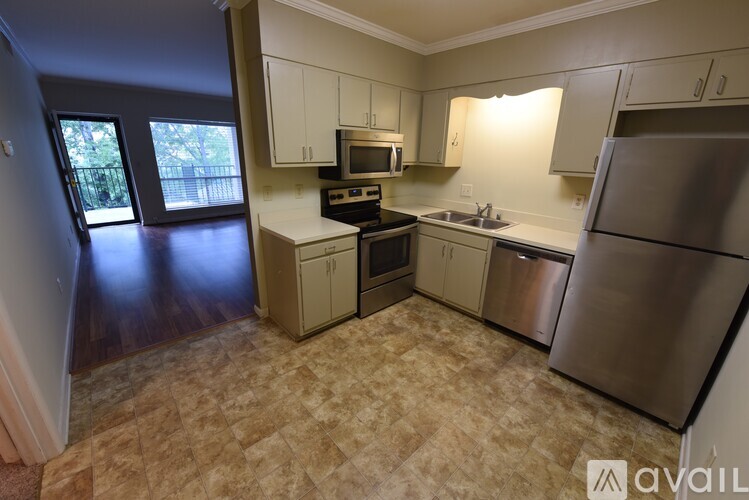 A kitchen with a refrigerator, stove, and microwave.