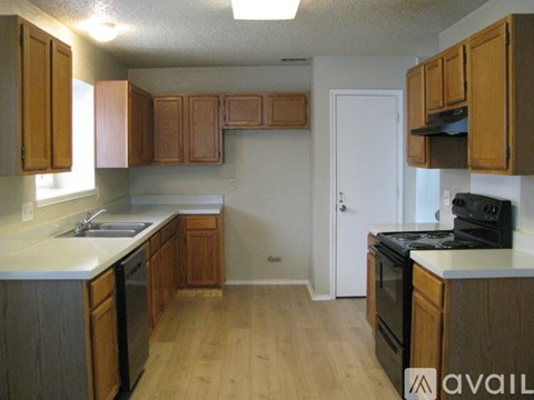 A kitchen with wooden cabinets and a black stove top oven.
