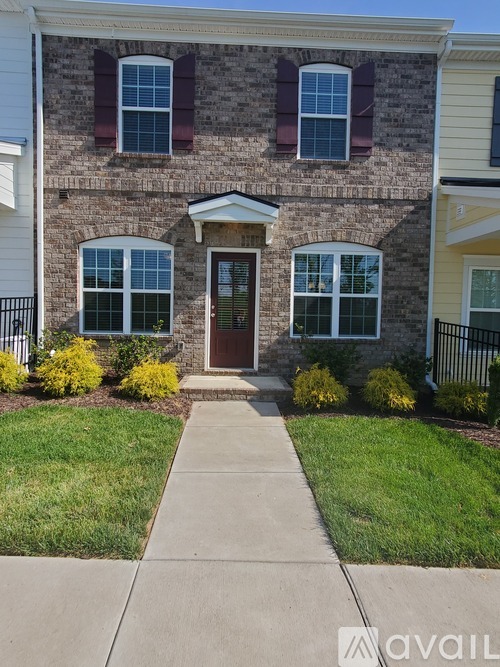 A house with a brown door and windows with red shutters.