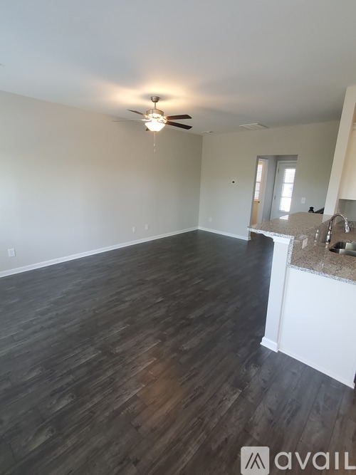 A room with wooden flooring and a ceiling fan.