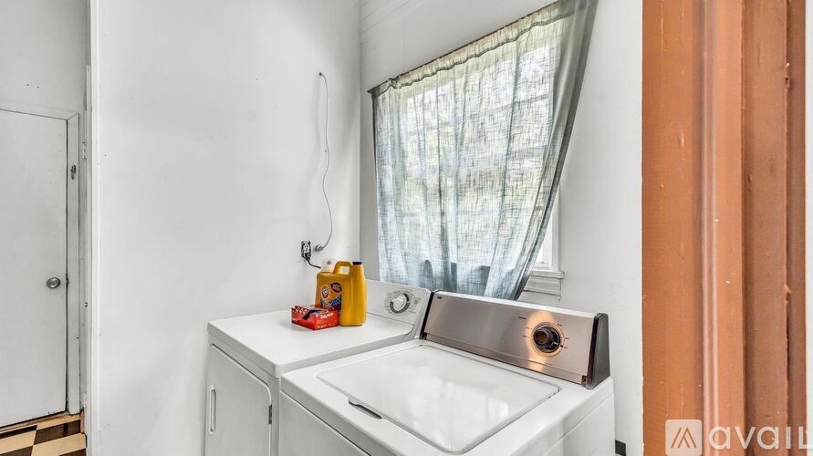 A white sink with a window above it and a white cabinet below it.