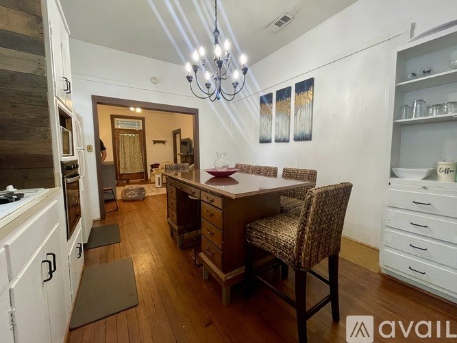 A kitchen with a dining table and chairs in the middle of the room.
