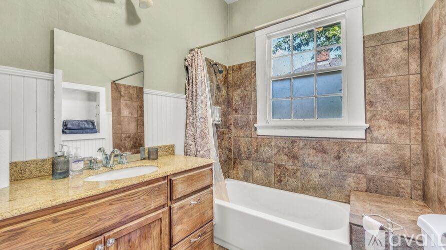 A bathroom with a window showing a tree and a house.