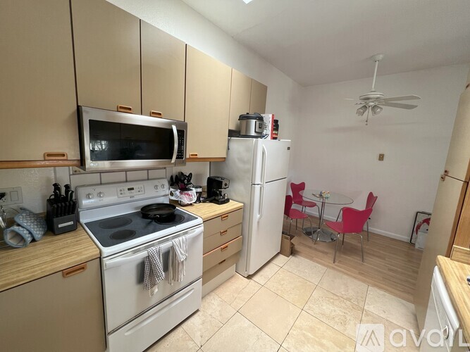 A kitchen with a white stove top oven and a white refrigerator.