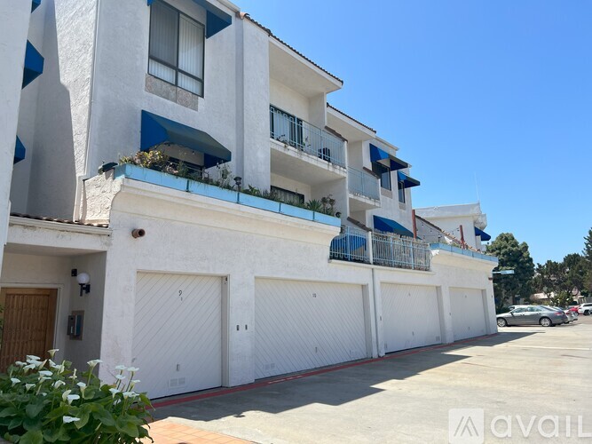 A white building with blue trim and balconies.