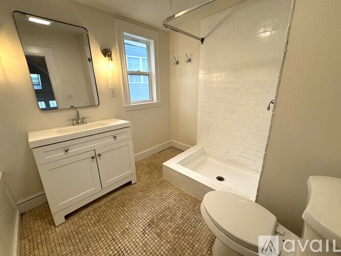 A hallway with a shelf on the right side and a black bag on the floor.