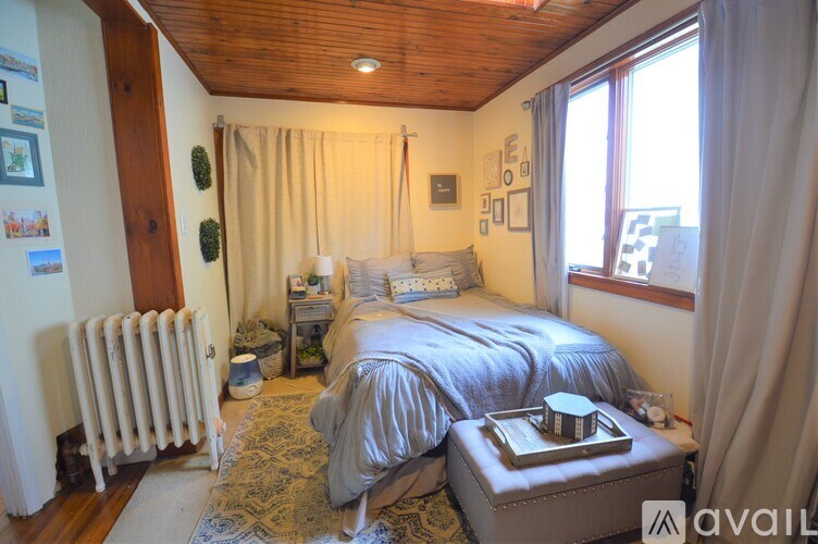 A bedroom with a bed, nightstand, and window.