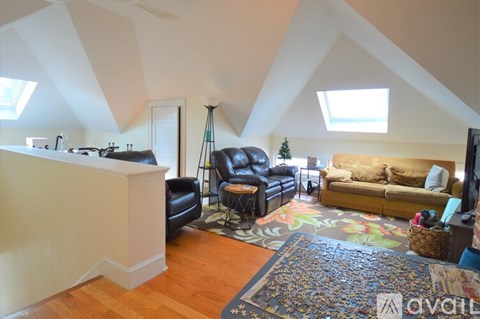 A living room with a brown rug and a yellow couch.