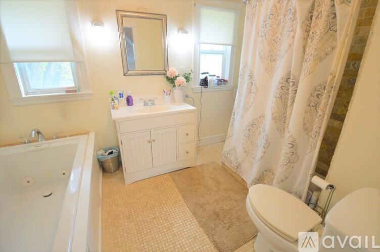 A bathroom with a tub, toilet, and sink.