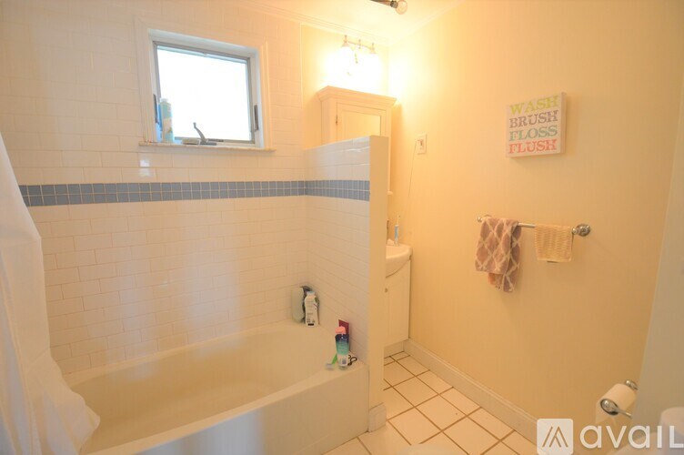 A bathroom with a tub, toilet, and sink.
