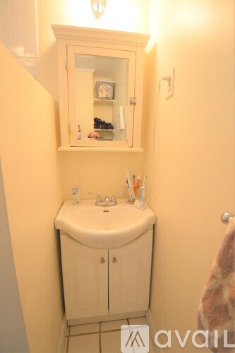 A bathroom with a sink and a cabinet above it.