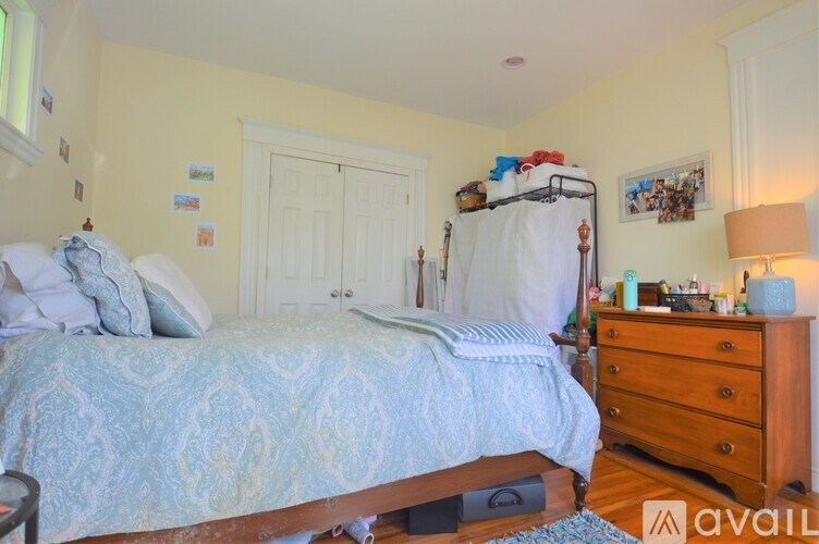 A bedroom with a bed, dresser, and a window.