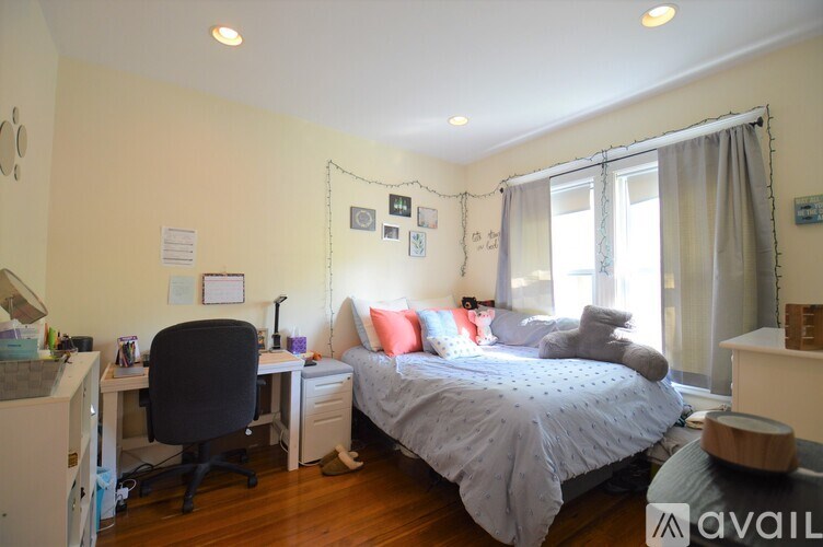 A bedroom with a bed, desk, and chair.