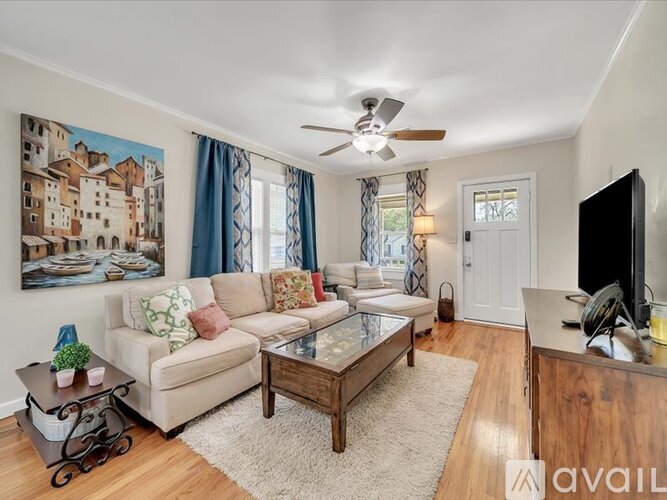 A living room with a couch, a coffee table, and a painting on the wall.