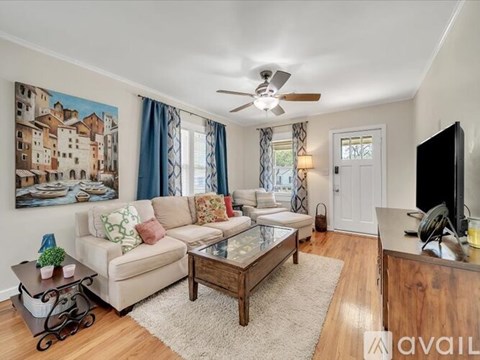 A living room with a couch, a coffee table, and a painting on the wall.