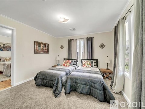 A bedroom with two beds and a carpeted floor.