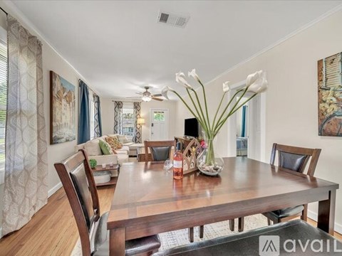A dining room with a wooden table and chairs.