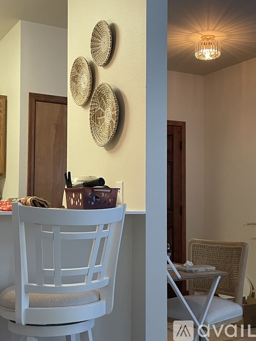 A white chair is in front of a table with a basket on it.