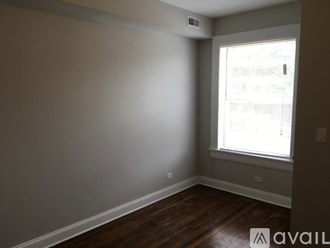 A room with a window and wooden floors.