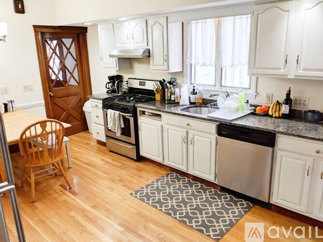 A kitchen with a wooden floor and white cabinets.