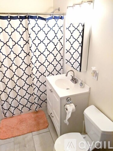A bathroom with a white sink and a toilet.