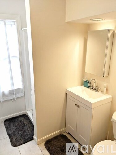 A white bathroom with a sink and a mirror.