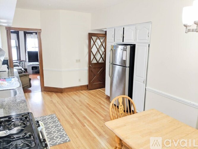 A kitchen with a wooden table and a refrigerator.