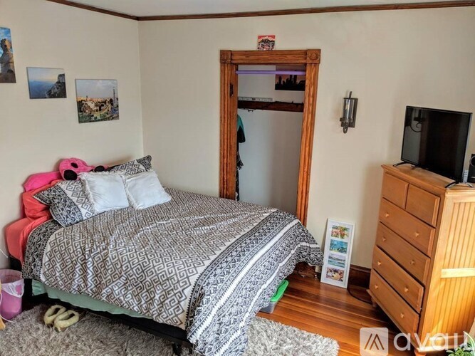 A bedroom with a bed, dresser, and mirror.