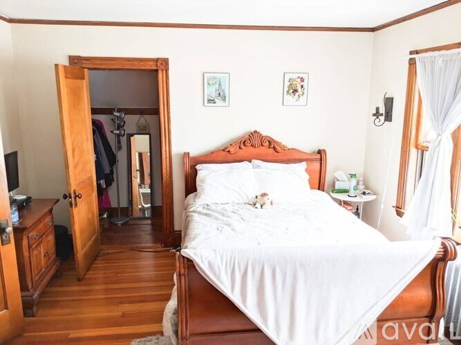 A bedroom with a large bed and a wooden floor.